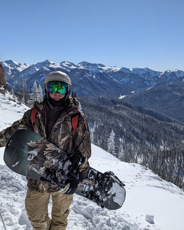 Brian snowboarding with mountain panorama
